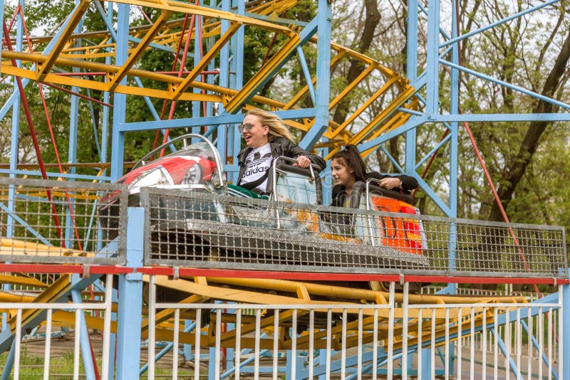 ODESSA, UKRAINE - MAJ 6, 2019: Besökare kör vägbilder i en nöjespark Unga vänner på en spännande rollercoaster Young arkivbild ODESSA, UKRAINE - MAJ 6, 2019: Besökare kör vägbilder i en nöjespark Unga vänner på en spännande rollercoaster Young arkivbild