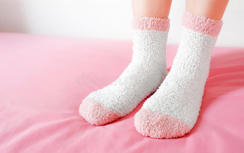 Legs of a beautiful women are wearing warm Socks on bedroom. Fashion pink Socks in cozy background. Pink socks. Legs of a beautiful women are wearing warm Socks on bedroom. Fashion pink Socks in cozy background. Pink socks.