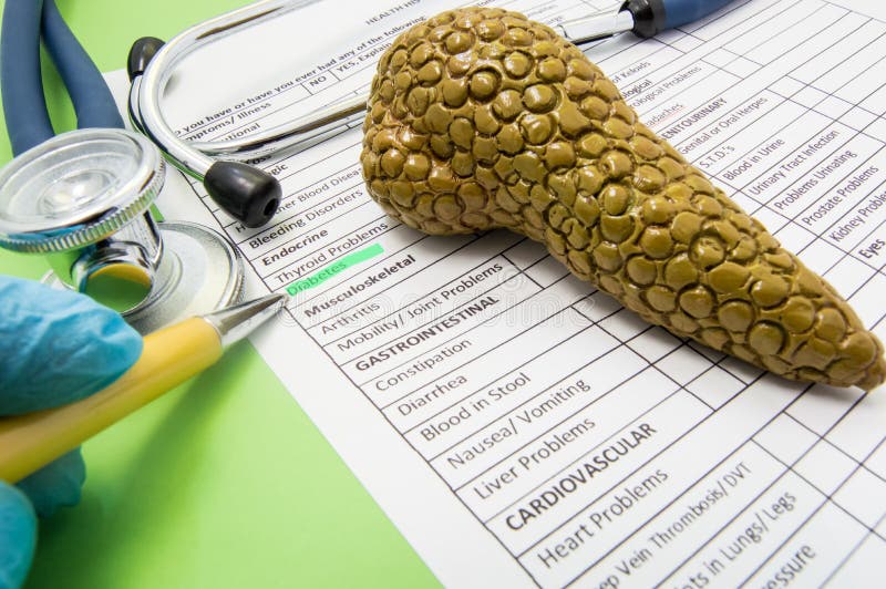 Diabetes and problems with pancreas in word photo scene. Doctor points to patient`s medical history to word diabetes under endocrinological problems near pancreas gland figure and stethoscope. Diabetes and problems with pancreas in word photo scene. Doctor points to patient`s medical history to word diabetes under endocrinological problems near pancreas gland figure and stethoscope