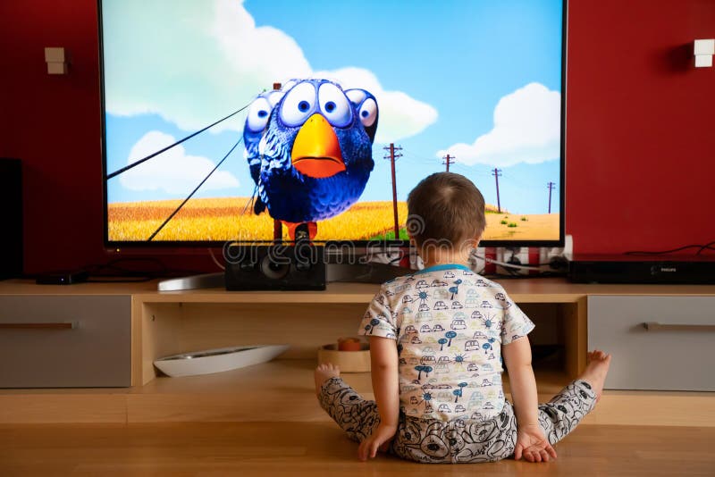 Prague, Czech Republic -18.03.2019: Small boy with Down syndrome watching cartoon on TV. Prague, Czech Republic -18.03.2019: Small boy with Down syndrome watching cartoon on TV