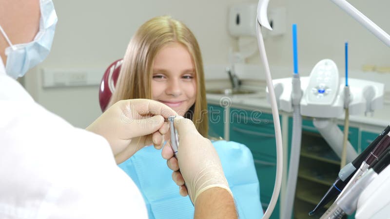 Konzept der Kinderzahnheilkunde und der zahnärztlichen Behandlung Hübsches 10-jähriges Mädchen in Zahnstuhl Männlicher Zahnarzt m stock footage