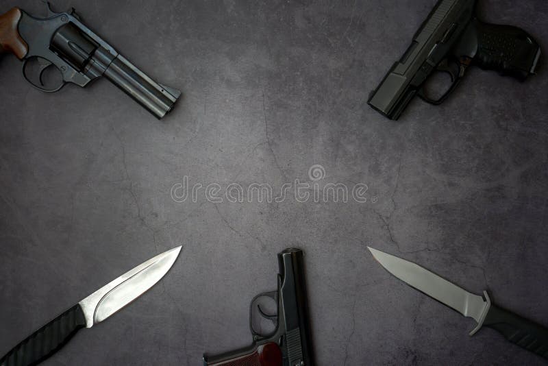 Feuerwaffen entlang der Linie Drei Pistolen, Armeemesser auf grauem Betonboden Kopierraum