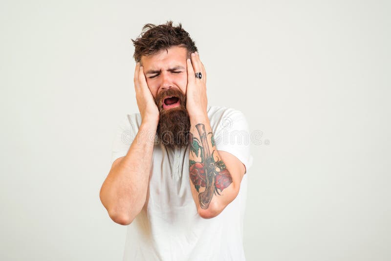 A mão de tatuagem masculina de um barbeiro profissional está segurando uma  tesoura contra uma barbearia de fundo branco e um conceito criativo de  cortes de cabelo