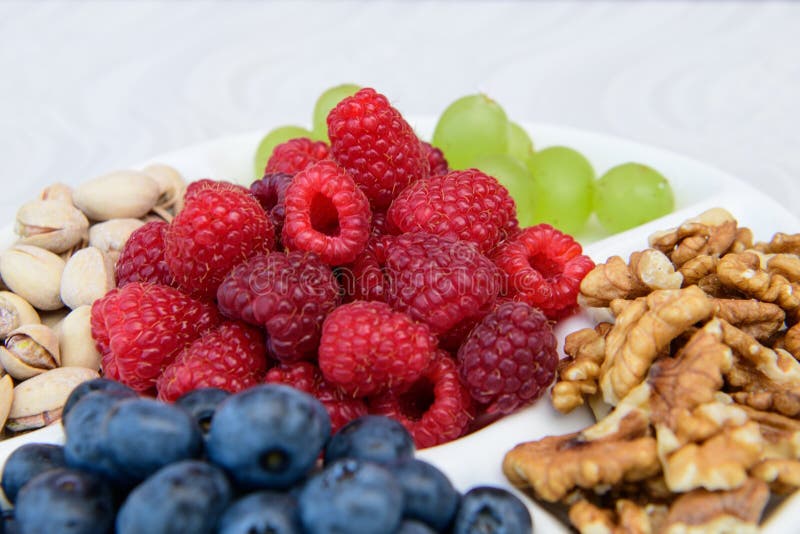 Healthy nutrition, berries and nuts. wild strawberries, grapes, blueberries, walnuts, pistachios. Eco food concept. Mixed berries and nuts. DSLR royalty free image, healthy breakfast or snack option mixed berries with mixed nuts, on a white plate. Healthy nutrition, berries and nuts. wild strawberries, grapes, blueberries, walnuts, pistachios. Eco food concept. Mixed berries and nuts. DSLR royalty free image, healthy breakfast or snack option mixed berries with mixed nuts, on a white plate.