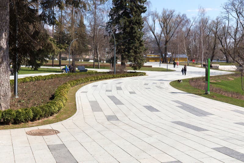 Caminos vientos en el Parque de la ciudad de Moscú Ciudadanos caminando por el parque Primavera nublada Paisaje urbano El VDNKH fotografía de archivo libre de regalías Caminos vientos en el Parque de la ciudad de Moscú Ciudadanos caminando por el parque Primavera nublada Paisaje urbano El VDNKH fotografía de archivo libre de regalías