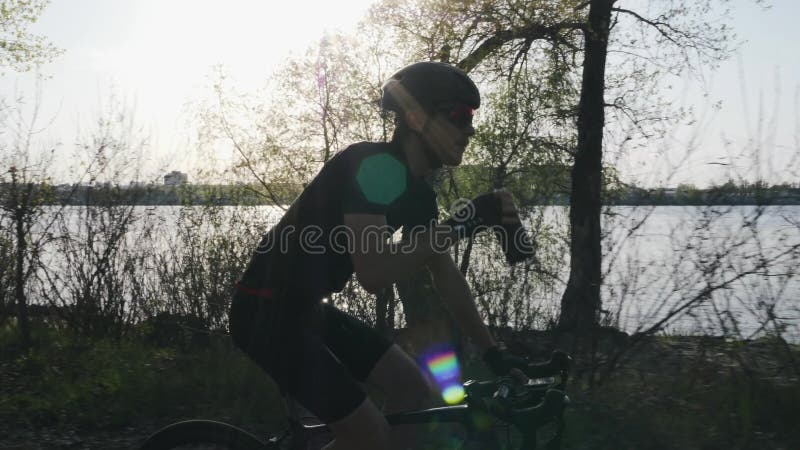 Profi-Radfahrer trinken Bidonwasser beim Fahrradfahren Fluss und Stadt im Hintergrund Radkonzept Langlauf