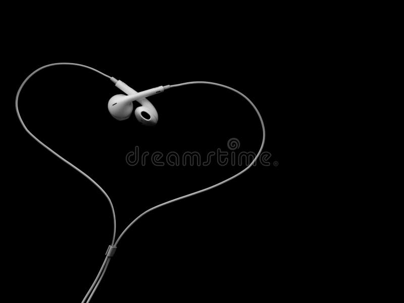 Earbuds de câble blancs d'écouteurs, casque sous forme de coeur sur un fond noir images stock Earbuds de câble blancs d'écouteurs, casque sous forme de coeur sur un fond noir images stock