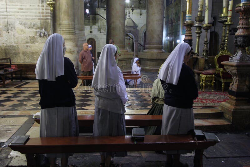 Nuns praying in the Church of the Holy Sepulchre in Jerusalem. Early in the morning before the arrival of pilgrims from around the world, nuns praying in the stock photography Nuns praying in the Church of the Holy Sepulchre in Jerusalem. Early in the morning before the arrival of pilgrims from around the world, nuns praying in the stock photography