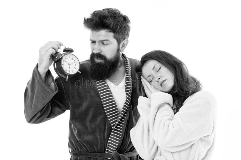An early morning hour. Sleepy woman and bearded man holding alarm clock early in the morning. Sexy girl and brutal royalty free stock images An early morning hour. Sleepy woman and bearded man holding alarm clock early in the morning. Sexy girl and brutal royalty free stock images