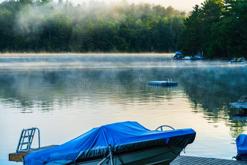 Early morning mist lifting from lake as the sunrises over the to
