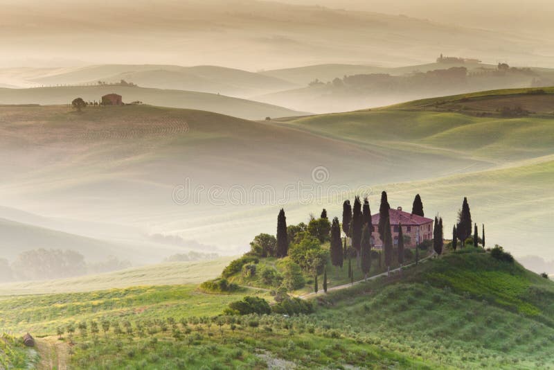 Mattina presto vista agriturismo con hazy colline sullo sfondo.