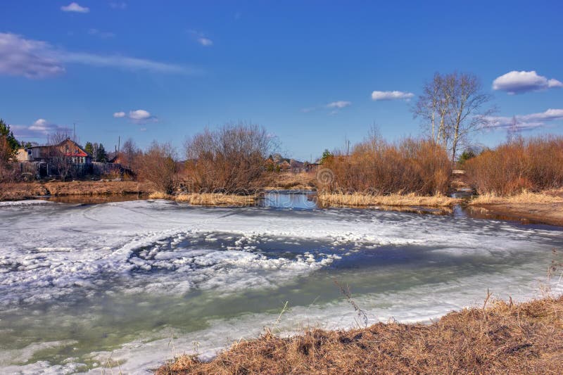 Early Spring Landscape Melts Ice on a Small River at the Edge of the