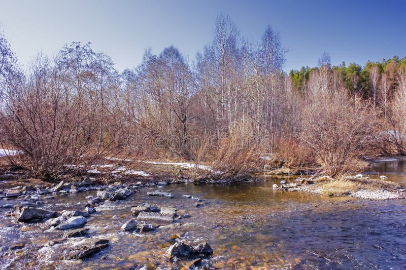 Early Spring Landscape Melts Ice on a Small River at the Edge of the
