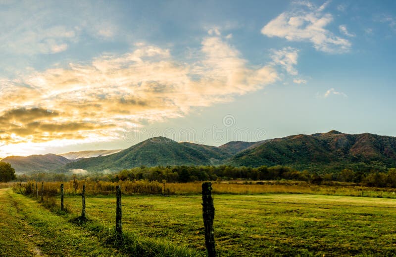 Smoky Mountain Sunrise along Sparks Lane, Cades Cove. Early Spring sun rising in Great Smoky Mountains National Park, glowing mountains background, meadow, lane royalty free stock photography Smoky Mountain Sunrise along Sparks Lane, Cades Cove. Early Spring sun rising in Great Smoky Mountains National Park, glowing mountains background, meadow, lane royalty free stock photography