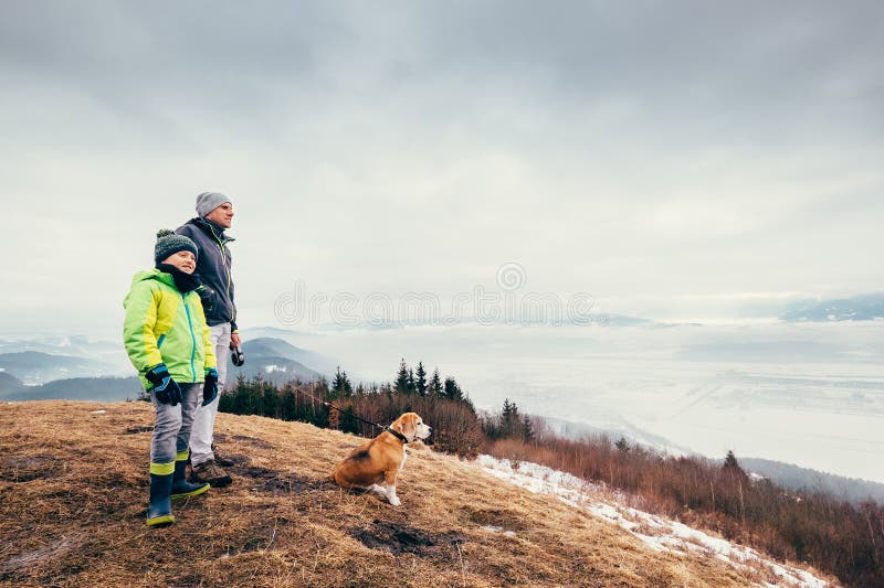 Early spring time - father with son walk with dog on mountain hi