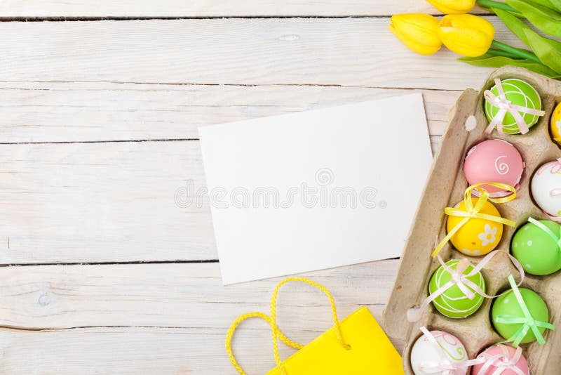 Easter background with colorful eggs and yellow tulips