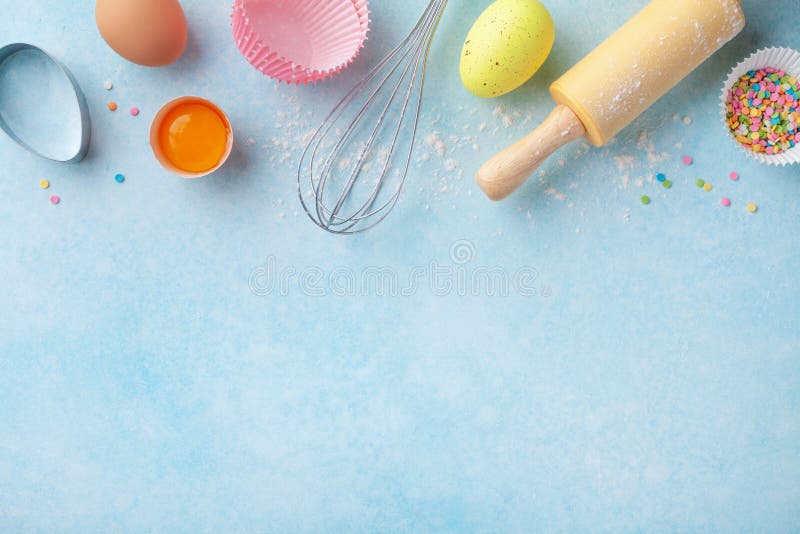 Easter baking background with rolling pin, whisk, eggs, flour and colorful confetti on blue table top view. Flat lay royalty free stock photography Easter baking background with rolling pin, whisk, eggs, flour and colorful confetti on blue table top view. Flat lay royalty free stock photography
