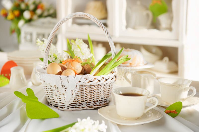 Easter basket full of eggs on a white festive table.