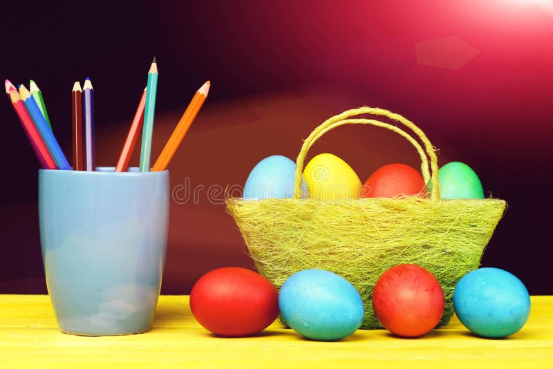 Easter bright composition holding painted Easter eggs and coloured crayons