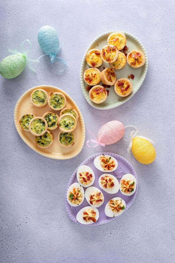 Easter brunch appetizers deviled eggs and mini quiches stock photos