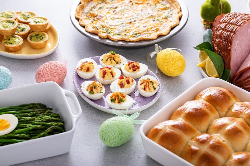 Easter brunch table with ham, quiche, hot cross buns stock image