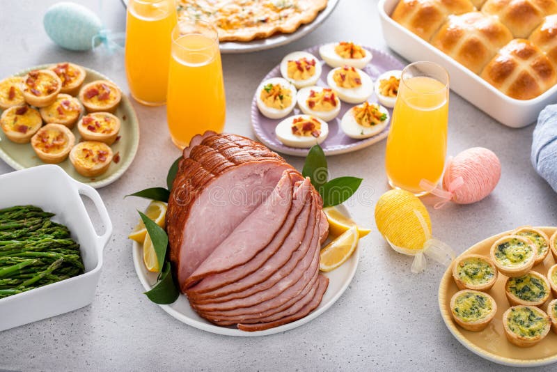 Easter brunch table with ham, quiche, hot cross buns stock image