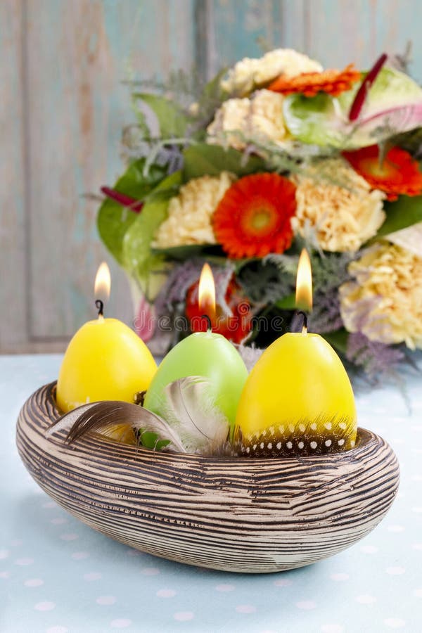 Easter Candles in Ceramic Bowl Decorated with Quail Feathers Stock