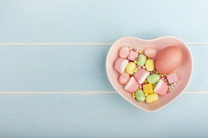 Easter colorful egg on a dish in the form of heart with sweets royalty free stock photo Easter colorful egg on a dish in the form of heart with sweets royalty free stock photo