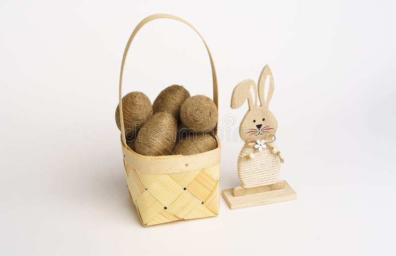 Easter Composition. Basket with Eggs Wrapped in Jute Twine. Wooden