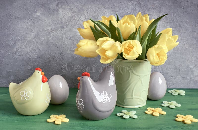 Easter composition with yellow tulips and ceramic hens with Easter eggs in green, yellow and gray royalty free stock photography