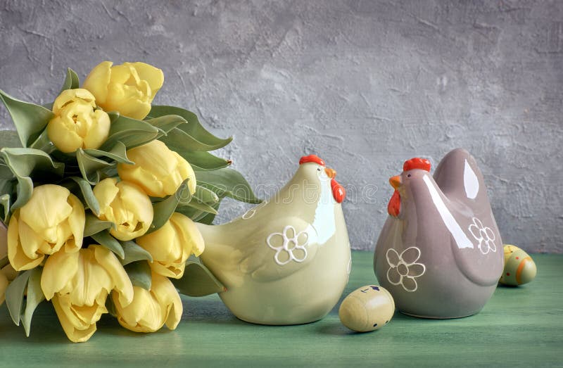 Easter composition with yellow tulips and ceramic hens with Easter eggs, space stock photography