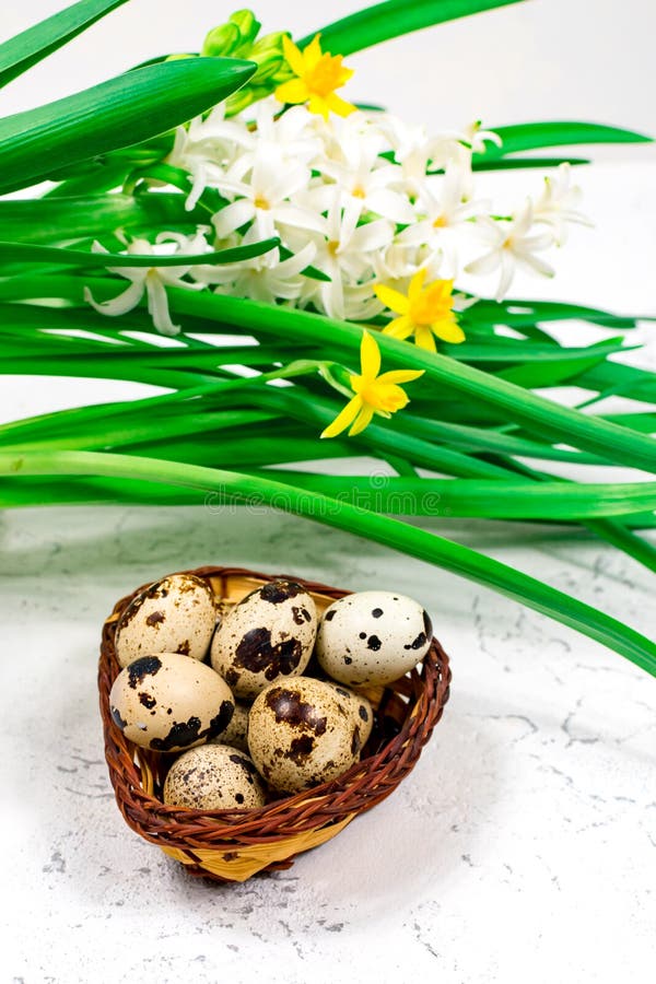 Easter Concept. Easter Eggs in a Basket Next To a Bouquet of Daffodils