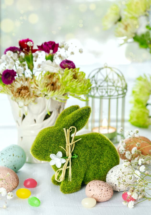 Easter decoration with Easter bunny, eggs and flowers on table