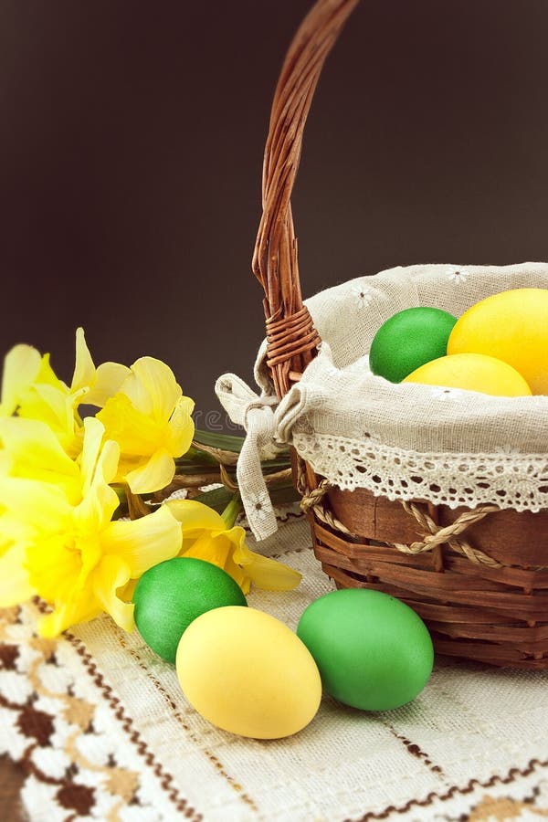 Easter eggs in the basket on wooden table with bouquet of daffodil royalty free stock photos Easter eggs in the basket on wooden table with bouquet of daffodil royalty free stock photos