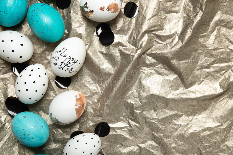 Easter eggs on a gold background with black confetti. Space for text