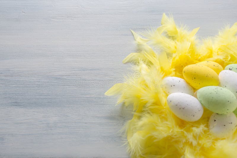 Easter Eggs on the yellow feathers and wooden table