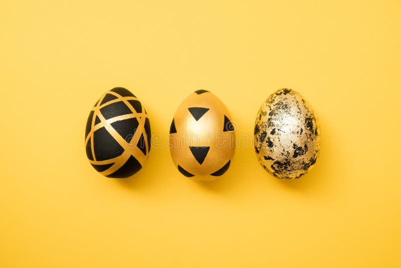 Easter golden decorated eggs on yellow background. Minimal easter concept. Happy Easter card with copy space for text.