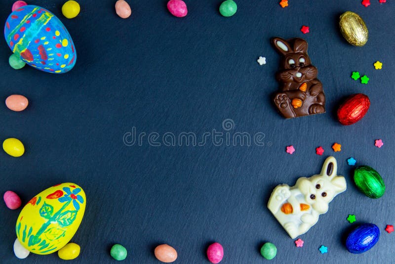 Easter greeting card with colorful candy frame and Easter egg, chocolate bunny and eggs