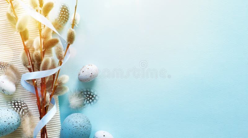 Easter greeting card with colorful easter eggs and sprin flowersl on blue table. Top view with space for your greetings - Image