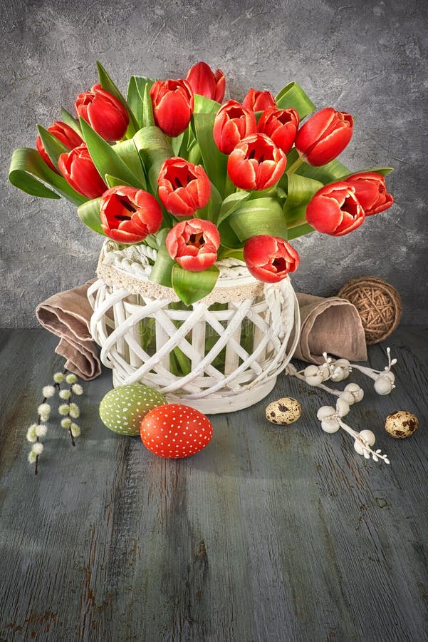Easter greeting card design with bunch of red tulips on rustic b