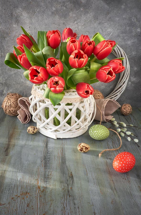 Easter greeting card design with bunch of red tulips on rustic b