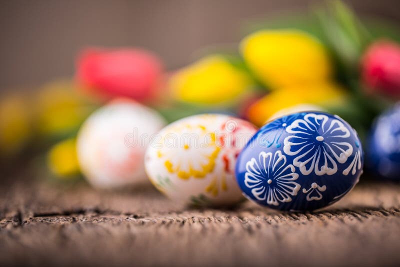 Easter. Hand made easter eggs and spring tulips on old wooden table