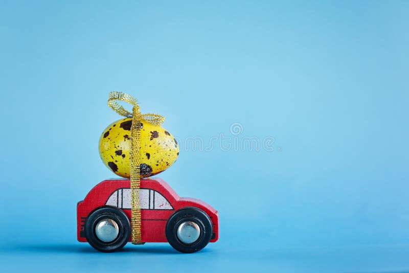 Easter holiday concept - Red toy car carrying yellow egg. Easter holiday concept - Red toy car carrying yellow egg stock photo Easter holiday concept - Red toy car carrying yellow egg. Easter holiday concept - Red toy car carrying yellow egg stock photo