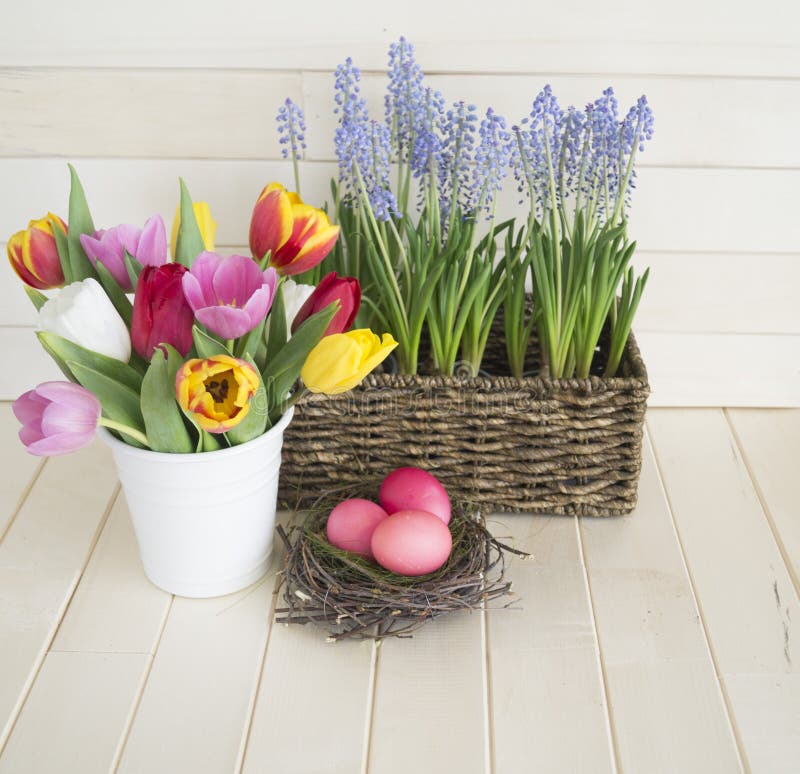 Easter. Pink easter eggs and tulips lie on a wooden background. Flat lay.