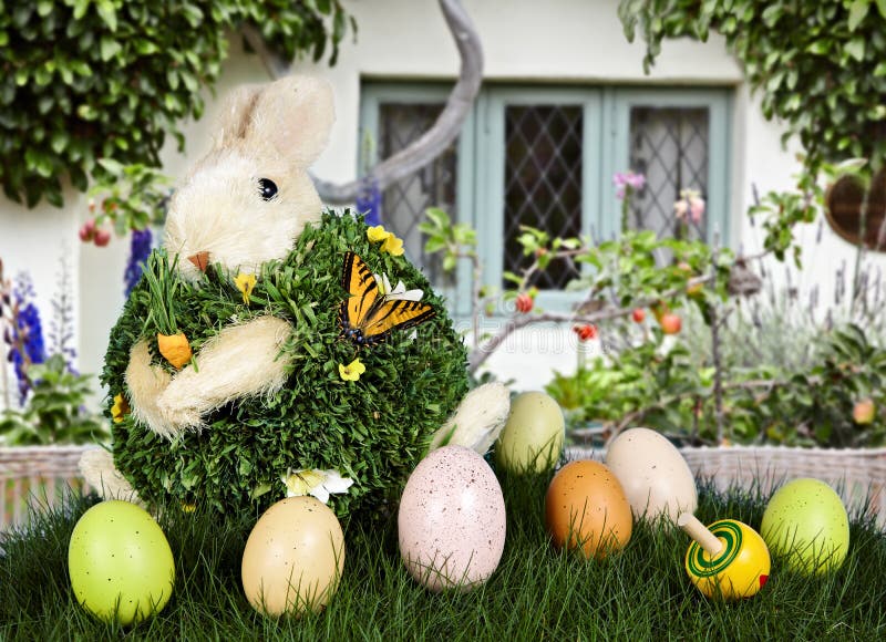 Easter Rabbit & Eggs In Green Grass With Cottage stock image