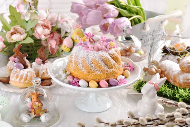 Easter ring cake with egg shaped candies and spring flower decoration on festive table