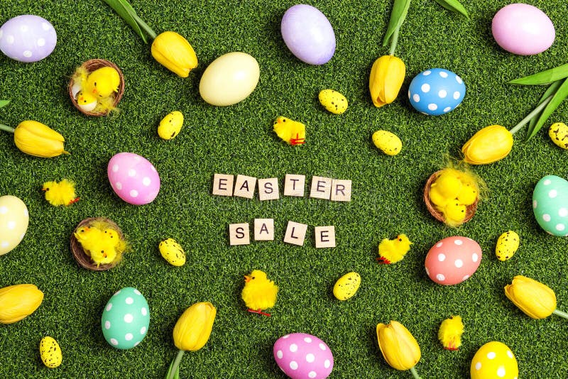 Easter sale banner with colorful eggs, tulips, chickens and sale text on a green grass background