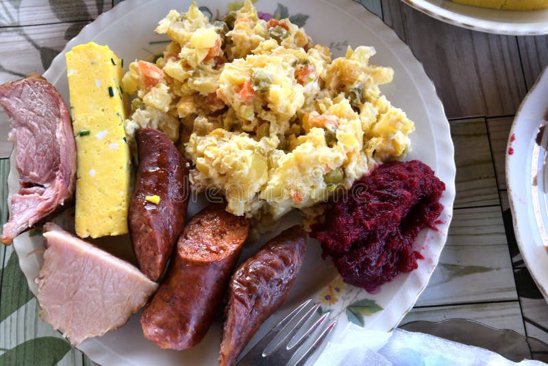 Easter table with salad, eggs, ham, sausage, beetroot and horseradish