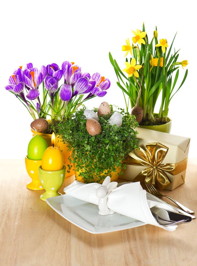 Festive easter table setting with spring flowers and eggs decoration on white background