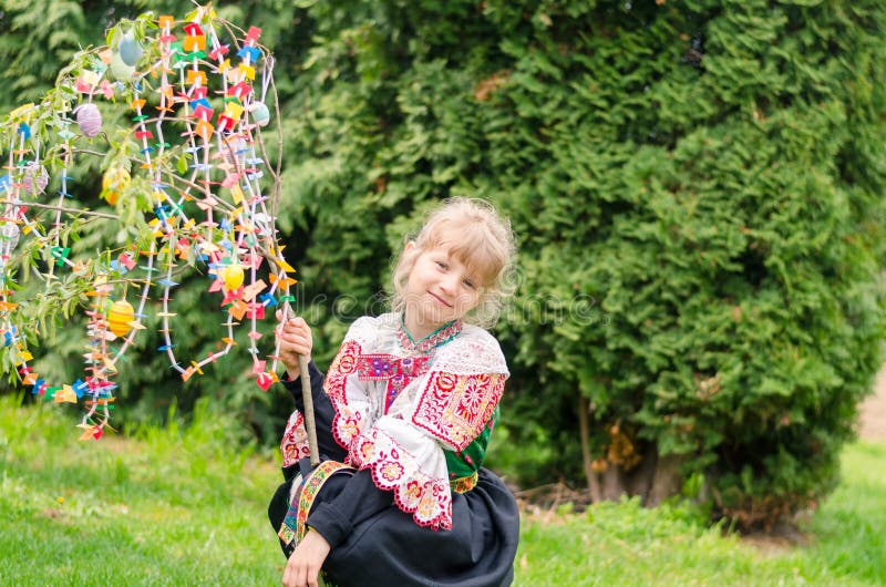 Easter traditional folk costume complimenting on Easter with colorful eggs hang on green branch